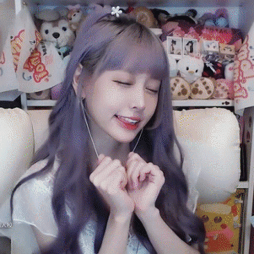 A Girl With Purple Hair And A Flower In Her Hair GIF