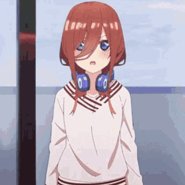 A Girl With Red Hair And Headphones Around Her Neck Is Standing In Front Of A Window . GIF
