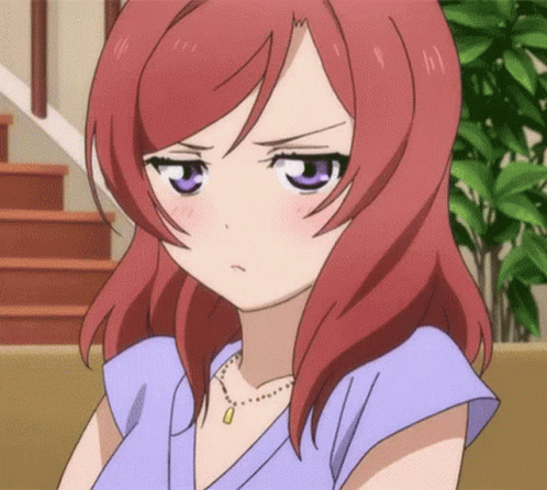 A Girl With Red Hair And Purple Eyes Is Wearing A Necklace And A Blue Shirt . GIF