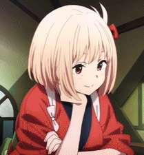 A Girl With Short Blonde Hair Is Wearing A Red Jacket And Has Her Hand On Her Chin GIF