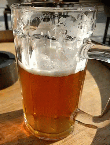 A Glass Filled With A Brown Liquid With Foam On Top GIF