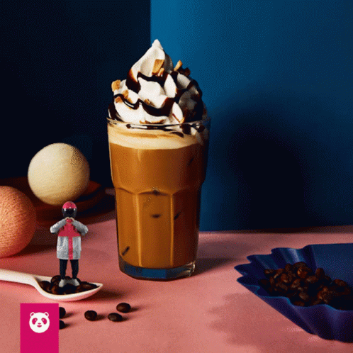 A Glass Of Coffee With Whipped Cream And Chocolate Sauce On Top GIF