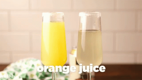 A Glass Of Orange Juice Is Being Poured Into A Glass Of Lemon Juice GIF
