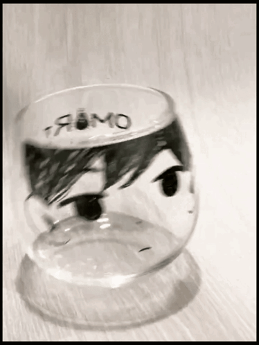 A Glass With A Drawing Of A Person 'S Face And The Word Fumo Written On It GIF