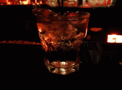 A Glass With A Straw In It Sits On A Bar Next To A Sign That Says Mrs. GIF