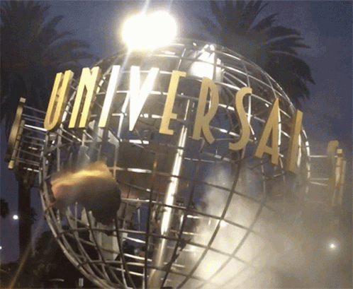 A Globe With Universal Written On It Is Lit Up At Night GIF