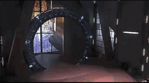 A Glowing Light Is Coming Out Of A Portal In The Middle Of A Room . GIF