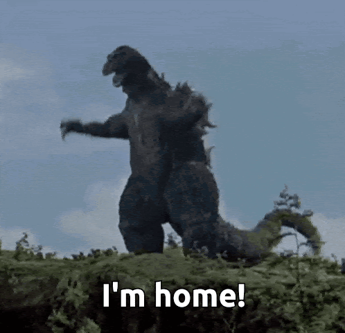 A Godzilla Is Standing On Top Of A Pile Of Grass And Says I 'M Home . GIF