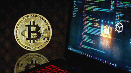 a gold coin with the letter b on it is next to a laptop