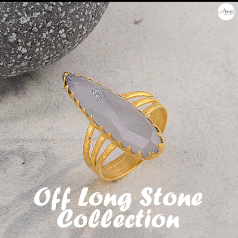 A Gold Ring With A Green Stone Sits On A Table With The Words Off Long Stone Collection Above It GIF