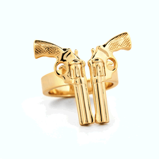 a gold ring with two guns on it on a white surface