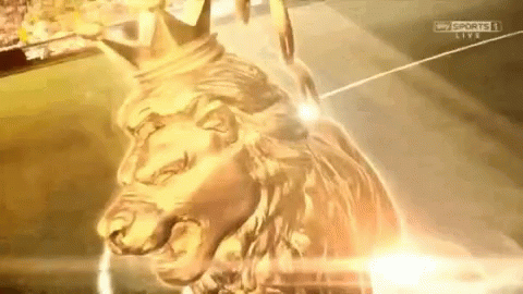 A Gold Statue Of A Lion With A Crown On It GIF