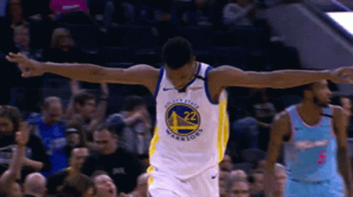 A Golden State Warriors Basketball Player Celebrates With His Arms Outstretched In Front Of A Crowd GIF
