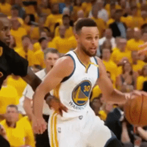 A Golden State Warriors Player Is Dribbling A Basketball In Front Of A Crowd GIF