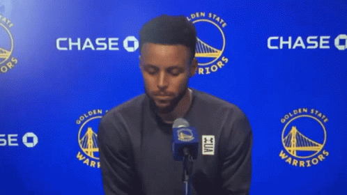 A Golden State Warriors Player Stands In Front Of A Chase Sign GIF