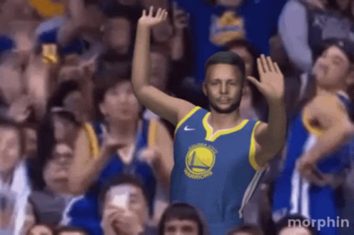 A Golden State Warriors Player Stands In Front Of A Crowd With His Hands In The Air GIF