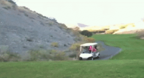A Golf Cart Is Driving Down A Path On A Golf Course With A Flag That Says U.s.a. GIF