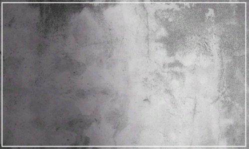 A Gray Concrete Wall With A White Frame In The Middle GIF