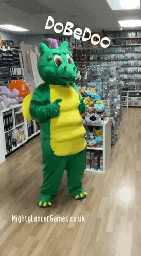 A Green And Yellow Dragon Mascot Is Standing In A Store With The Words Dobedoo On The Top GIF