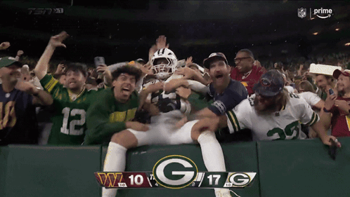 A Green Bay Packers Player Is Surrounded By Fans During A Football Game GIF
