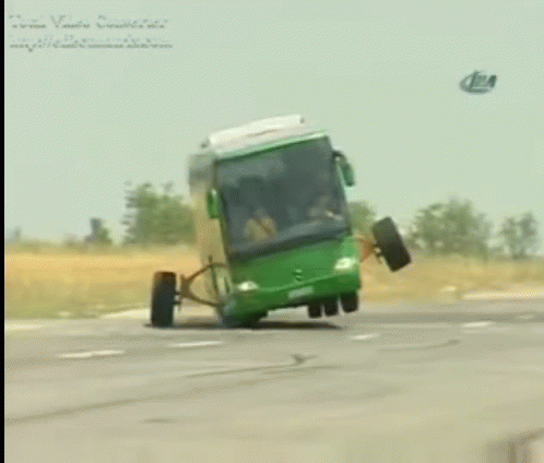A Green Bus With A Broken Wheel Is Driving Down A Highway GIF