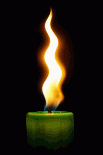 A Green Candle With A Yellow Flame On It GIF