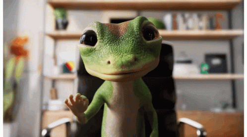 A Green Gecko Is Sitting In An Office Chair And Waving GIF