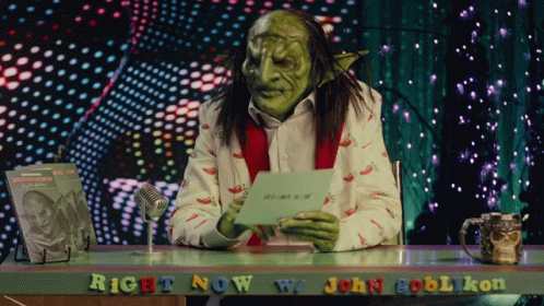 A Green Goblin Is Sitting At A Desk With The Words Right Now W/ John Goblikon GIF