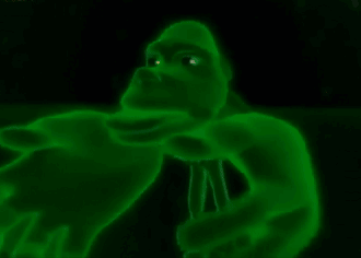 A Green Gorilla With Glowing Eyes Is Holding A Microphone In The Dark . GIF