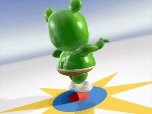A Green Gummy Bear Is Standing On A Blue And Red Circle GIF