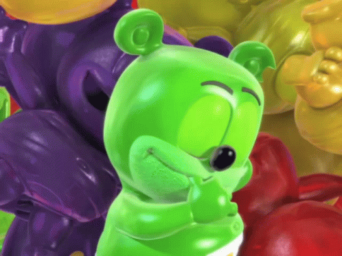 A Green Gummy Bear Standing In Front Of A Pile Of Gummy Bears GIF