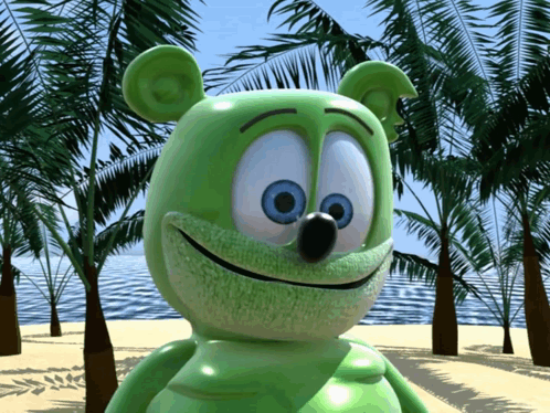 A Green Gummy Bear With Blue Eyes Is Standing On A Beach GIF