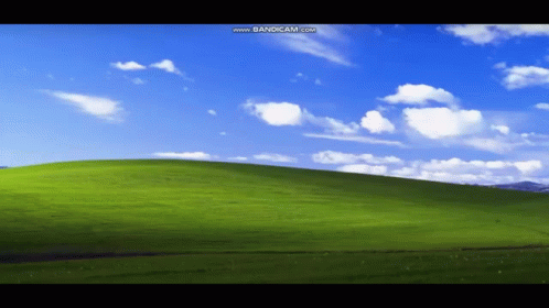 A Green Hill With A Blue Sky And White Clouds Is Displayed On A Computer Screen GIF