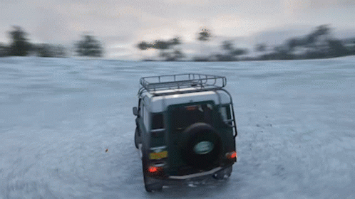 A Green Land Rover Driving Through The Snow GIF