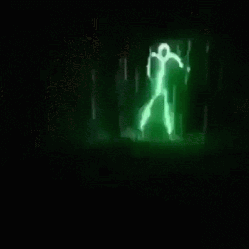 A Green Light Is Shining In The Dark And Looks Like A Person Walking . GIF
