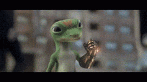A Green Lizard Is Holding A Gold Object In Its Hand And Giving A Thumbs Up . GIF