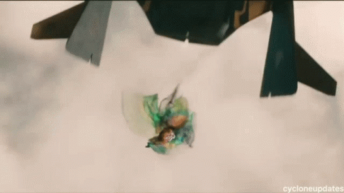 A Green Object Is Floating In The Air With A Jet Flying In The Background . GIF