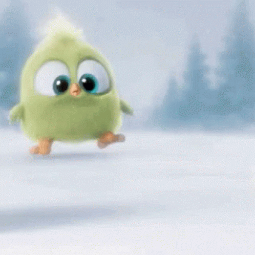 A Green Stuffed Animal With Big Eyes Is Walking In The Snow . GIF