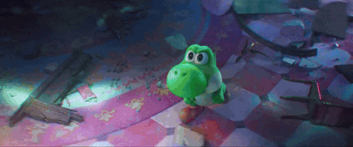 A Green Yoshi Toy Is Standing On A Checkered Floor . GIF