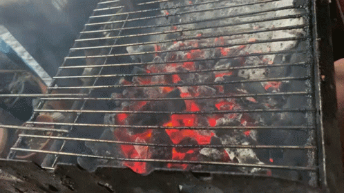 A Grill With A Lot Of Coals On It And Smoke Coming Out Of It GIF