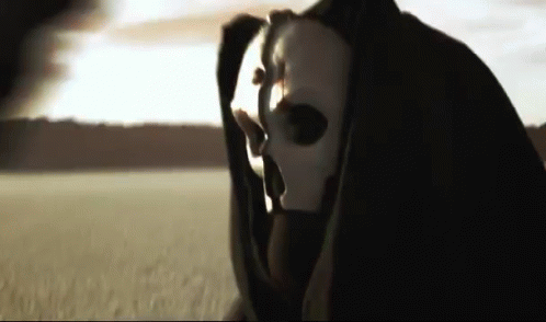 A Grim Reaper Is Wearing A White Mask And A Black Cape GIF