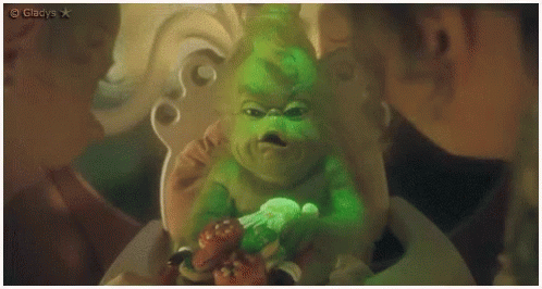 A Grinch Is Sitting In A Chair And Looking At The Camera With A Caption That Says Gladys GIF