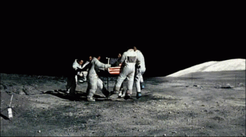A Group Of Astronauts Are Standing Around An American Flag On The Moon GIF
