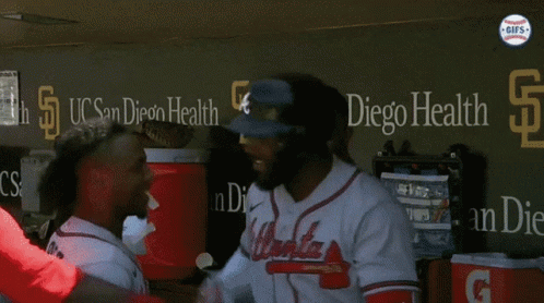 A Group Of Atlanta Braves Baseball Players Stand In A Dugout GIF