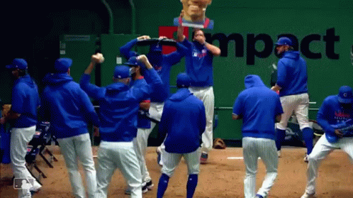 A Group Of Baseball Players Are Dancing In Front Of A Wall That Says Impact GIF