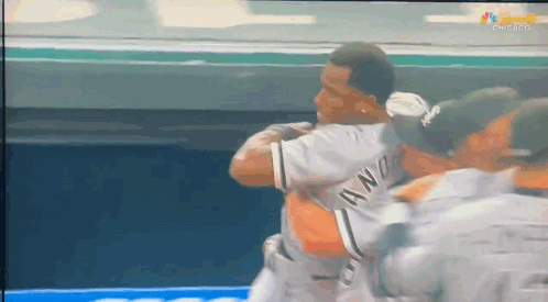 A Group Of Baseball Players Are Hugging Each Other And One Of Them Is Wearing A Jersey That Says ' Awn ' GIF