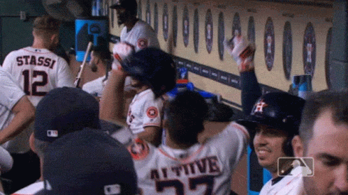 A Group Of Baseball Players Are Sitting In A Dugout And One Of Them Has The Number 27 On His Back GIF
