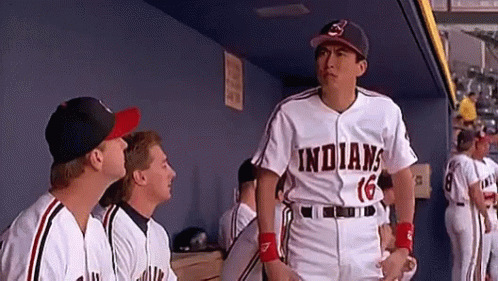 A Group Of Baseball Players Are Standing In A Dugout And One Of Them Is Wearing A Jersey That Says Indians GIF