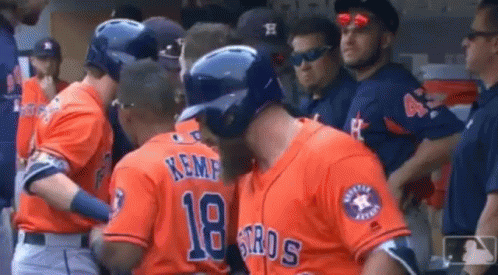 A Group Of Baseball Players Are Standing In The Dugout . GIF