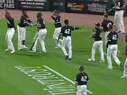 A Group Of Baseball Players Are Standing On A Field Holding Bats . GIF